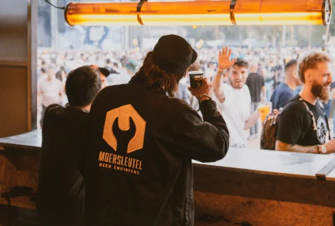 Two people of Moersleutel Craft Brewery cheers with their beers to people at V and B Fest in France